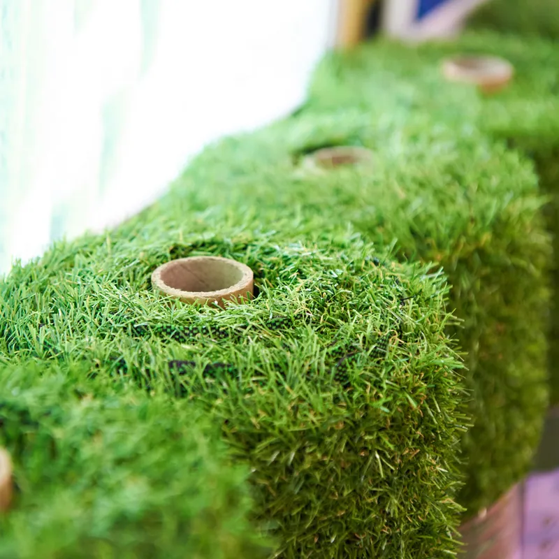 Three rectangular pieces of Artificial Turf Grass Flooring, each with a central circular hole, aligned in a row