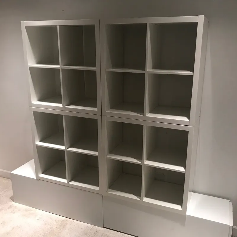 The Simple Storage Backdrop, four white cube-shaped shelving units in two columns with the right one tilted, on a white base