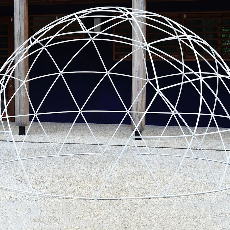 Geodesic Dome with a sturdy metal frame standing outdoors on gravel in front of wooden columns