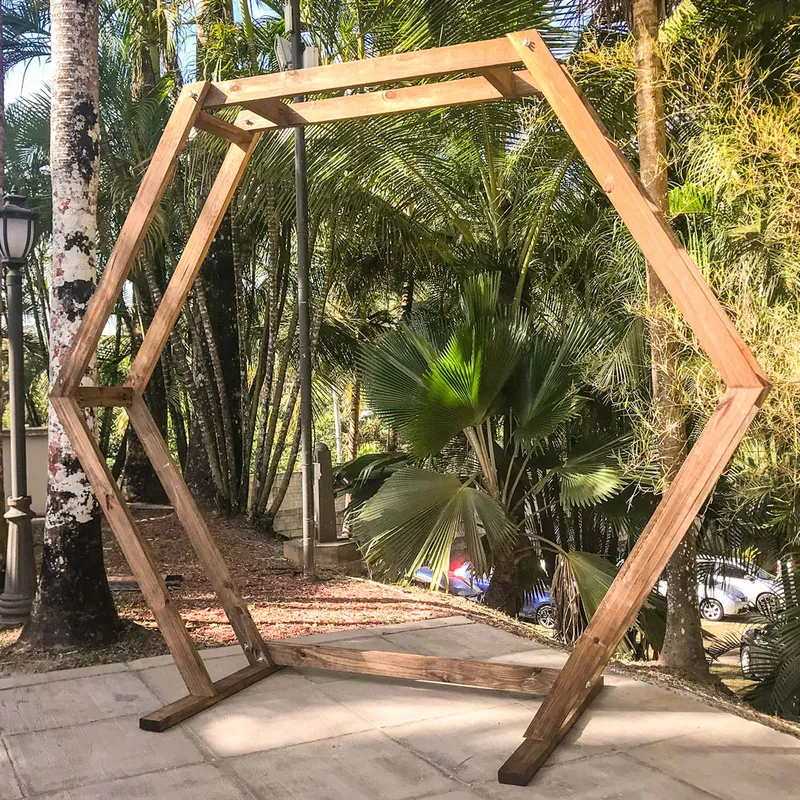 The Geometric Arch standing outdoors on a paved area, surrounded by tall trees and greenery