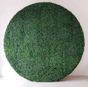A large, circular artificial hedge wall with dense green foliage from Trinidad Event Hire stands against a plain white background. - Perched Event Rentals, Trinidad
